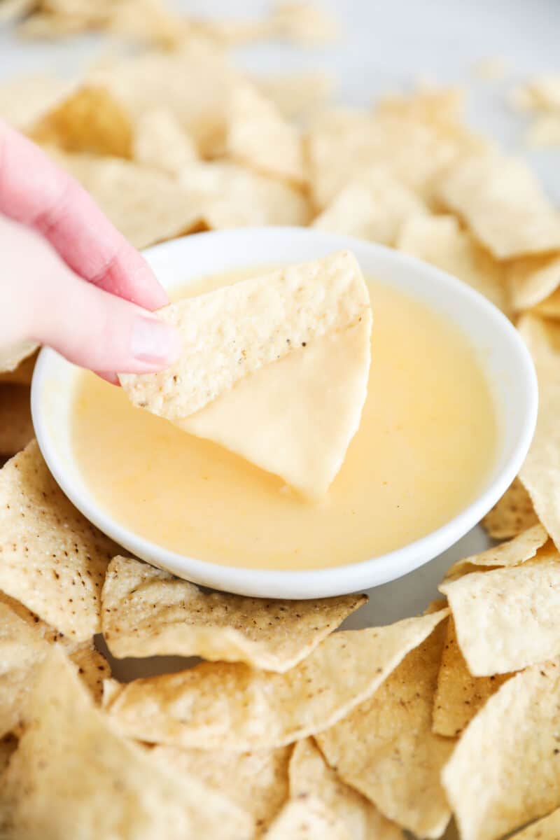 nacho cheese dip and chips on table