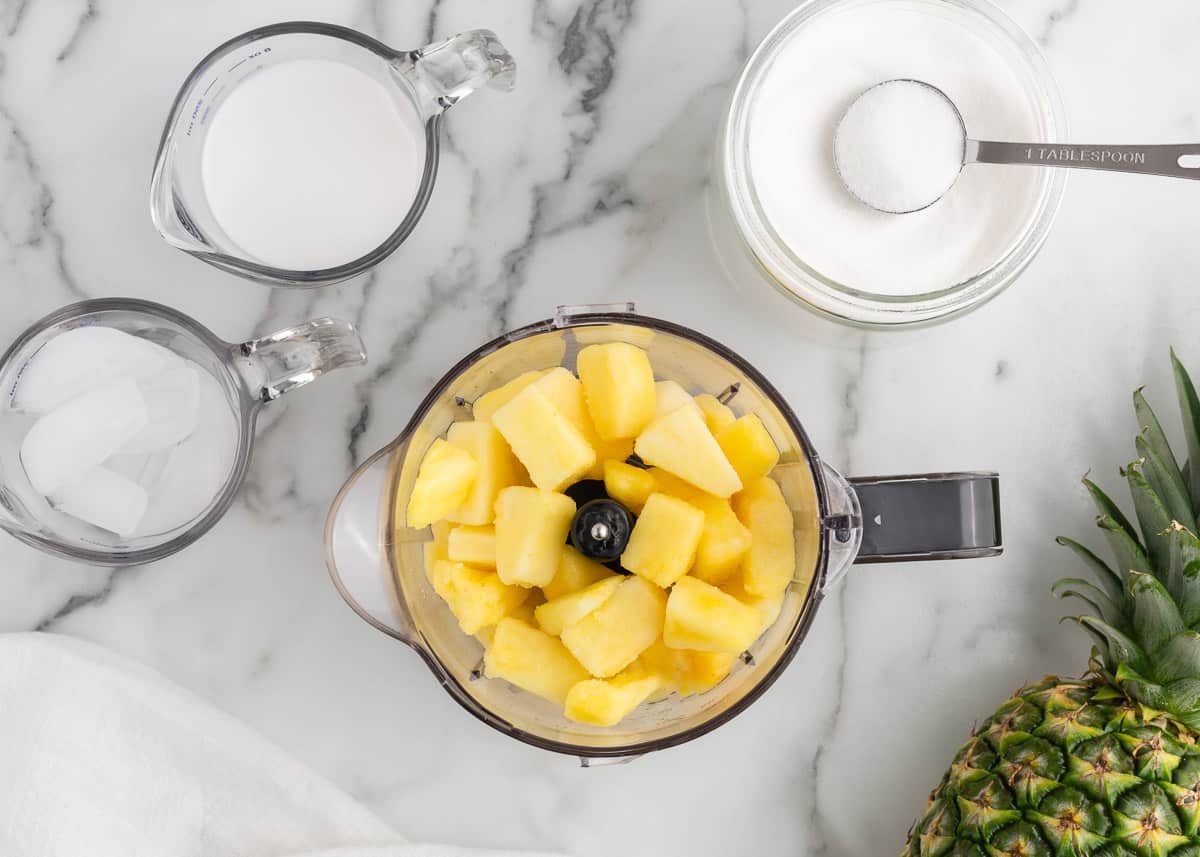 Pina colada smoothie ingredients on counter.