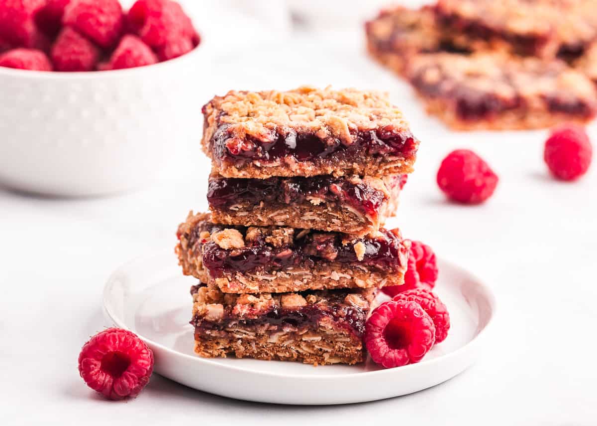 Raspberry crumb bars on white plate.