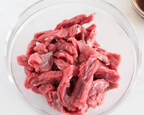 teriyaki raw steak slices in clear bowl