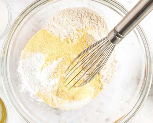 whisking flour and cornmeal in a bowl