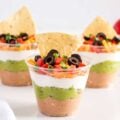 7 layer dip in plastic cups with tortilla chips