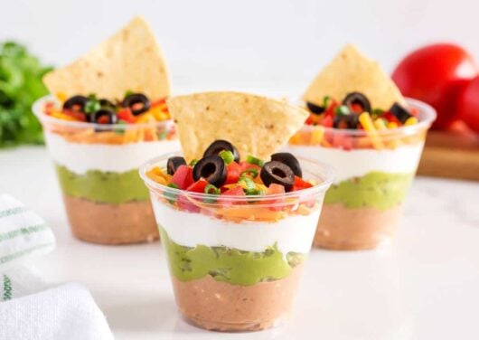 7 layer dip in plastic cups with tortilla chips