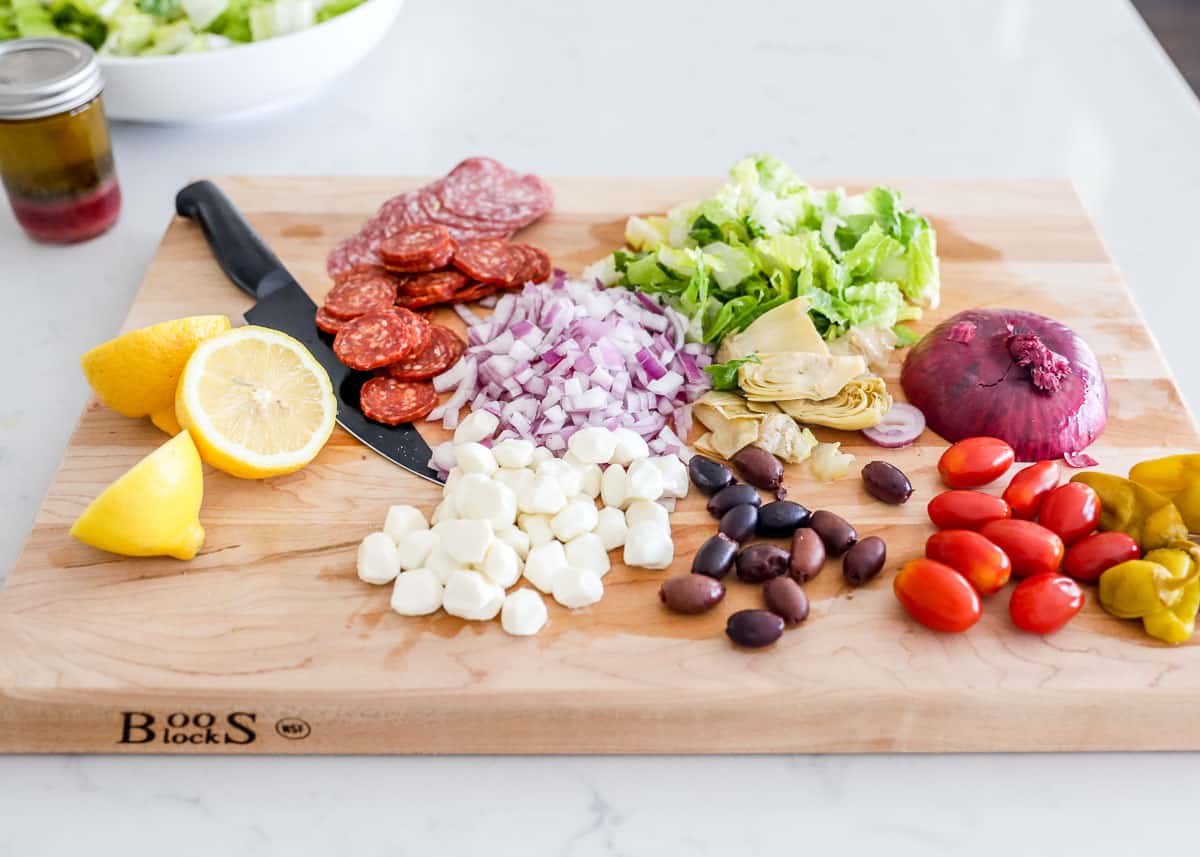 Antipasto salad ingredients on cutting board.