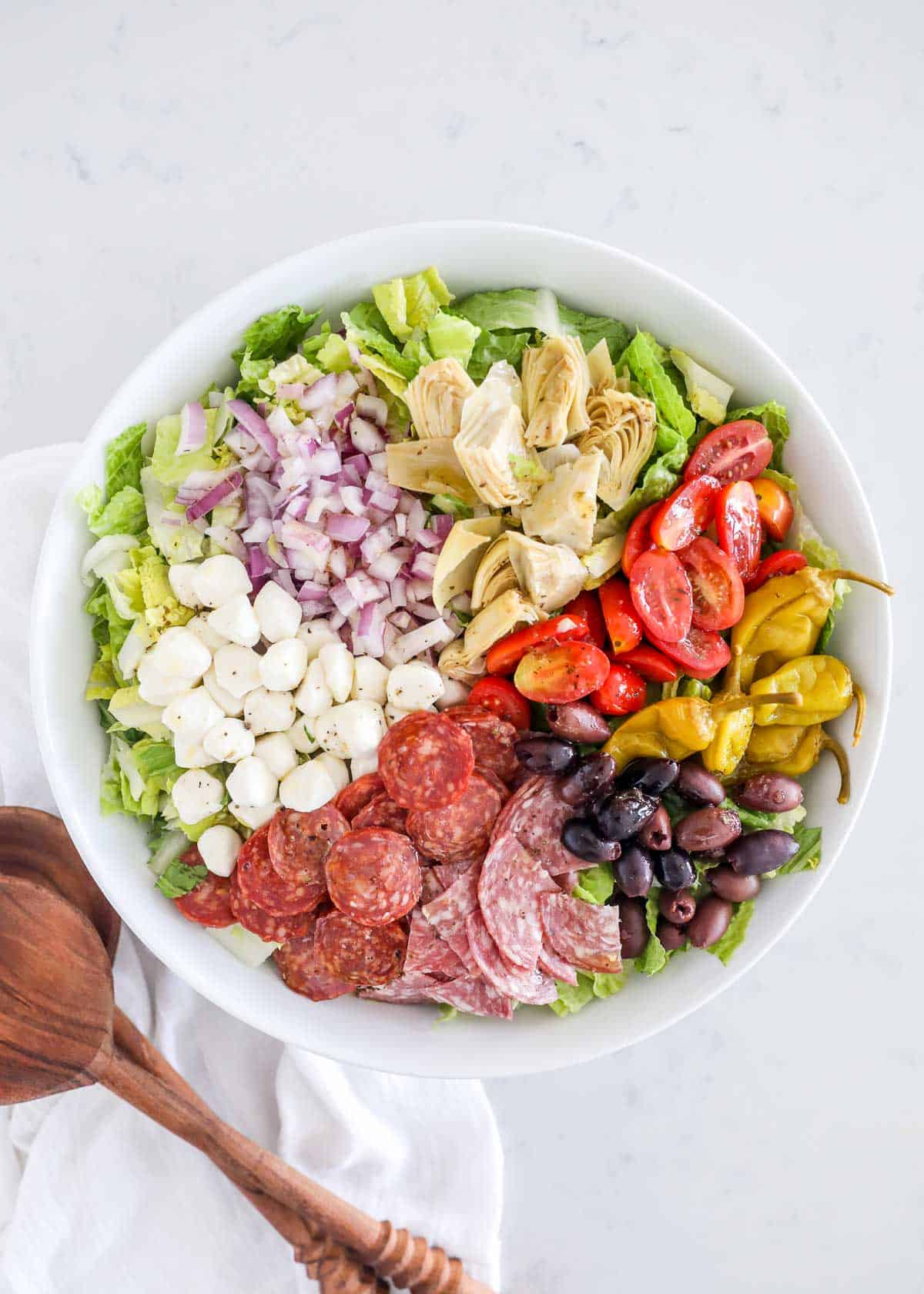 Antipasto salad in white bowl.