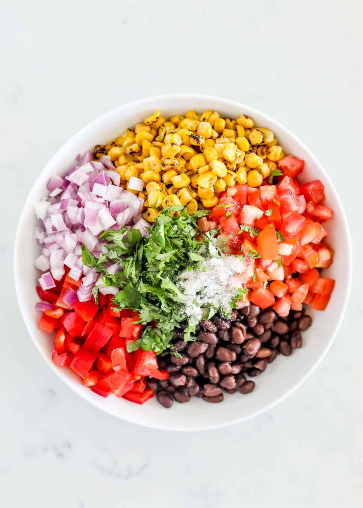 Black bean salsa ingredients in white bowl.