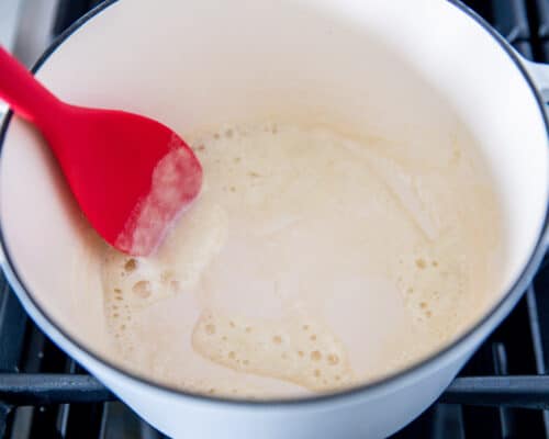 mixing roux in pot with red spoon
