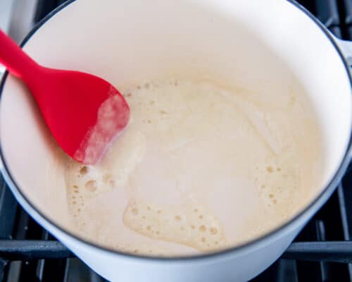 mixing roux in pot with red spoon