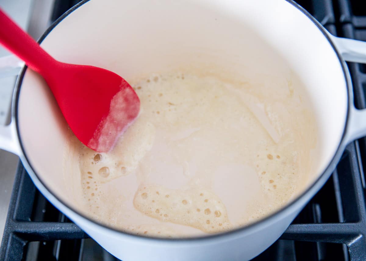 mixing roux in pot with red spoon