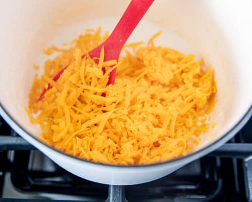 mixing shredded cheese in pot