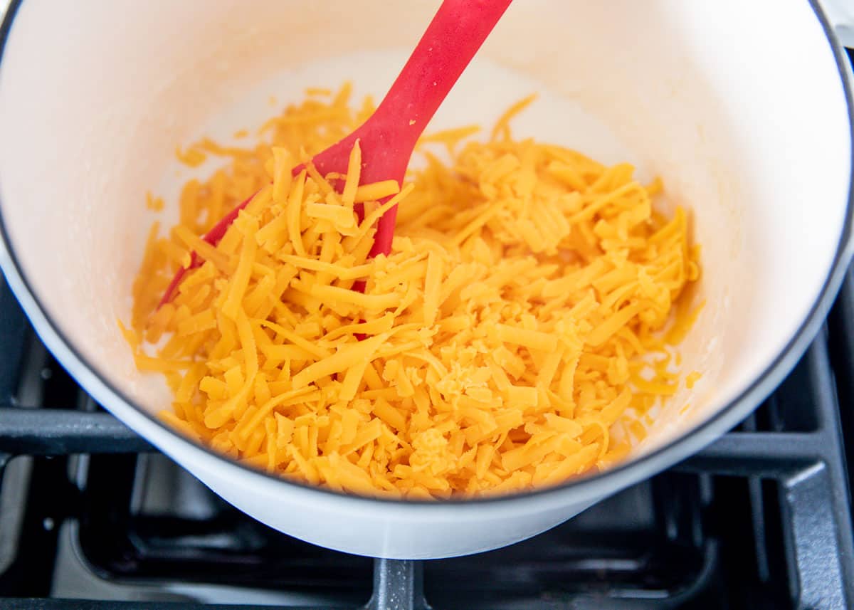 mixing shredded cheese in pot