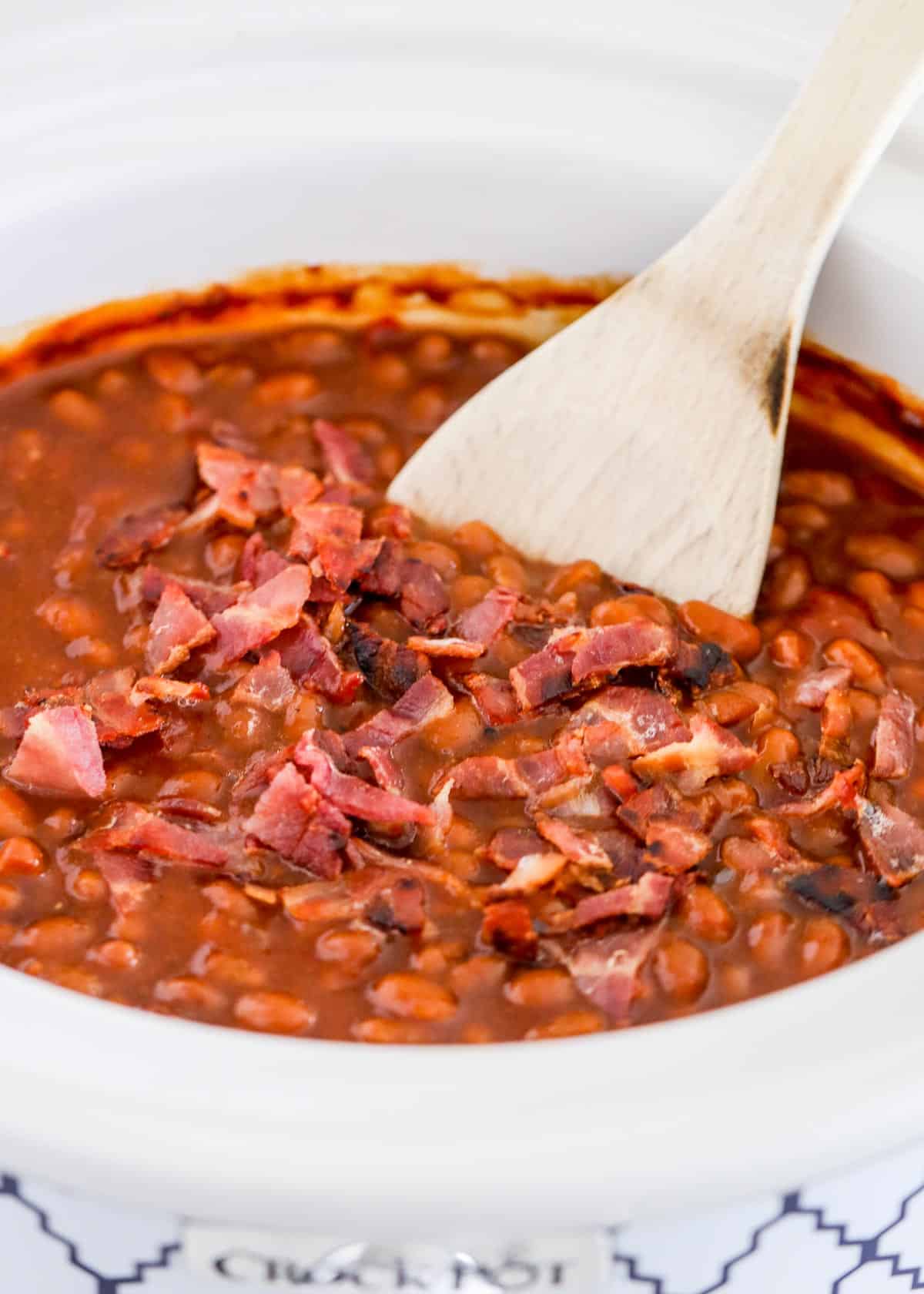 Wooden spoon in baked beans.