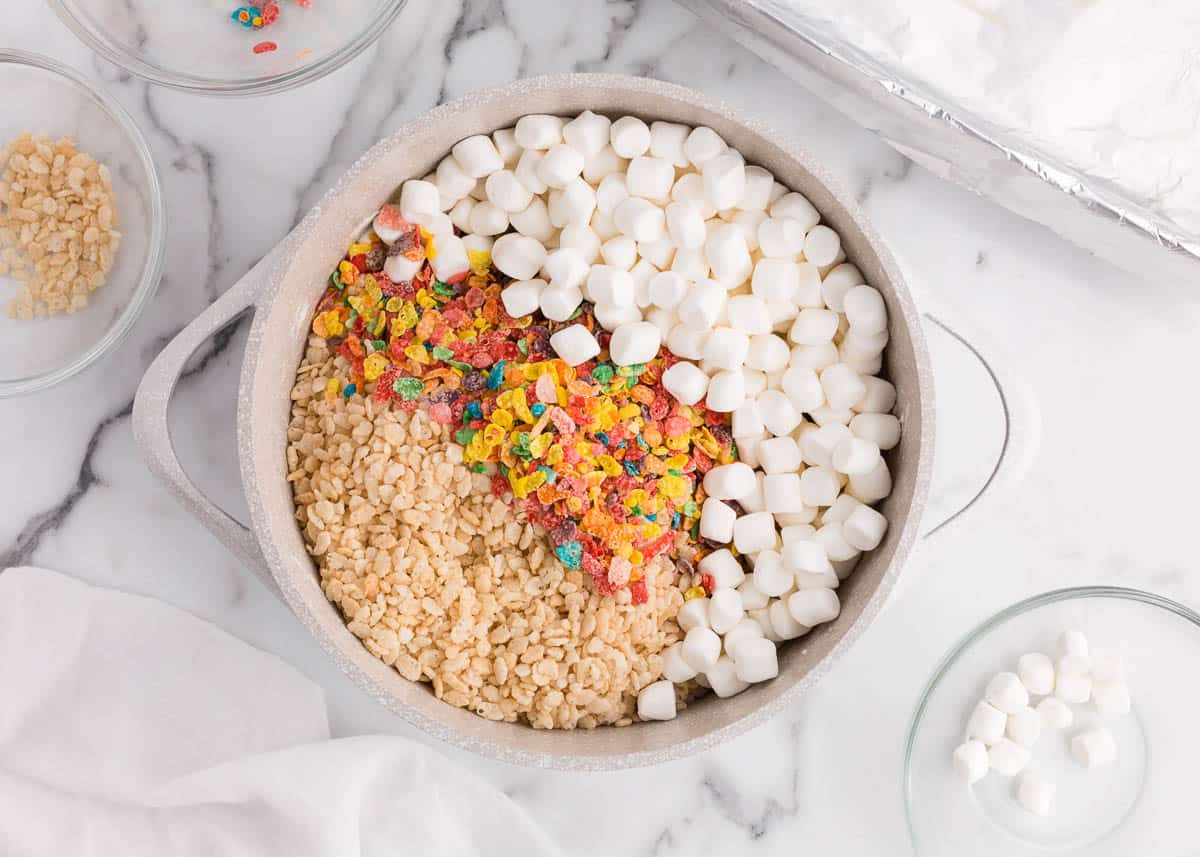 Rice krispies, fruity pebbles and marshmallows in pot.
