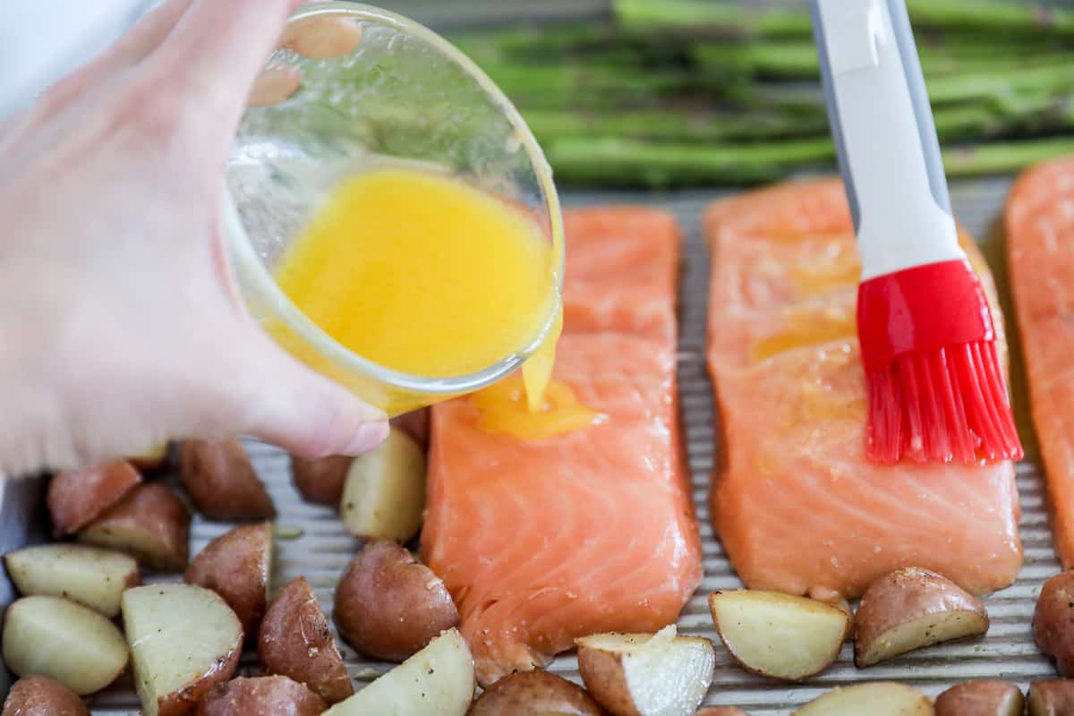 Pouring butter sauce over salmon.