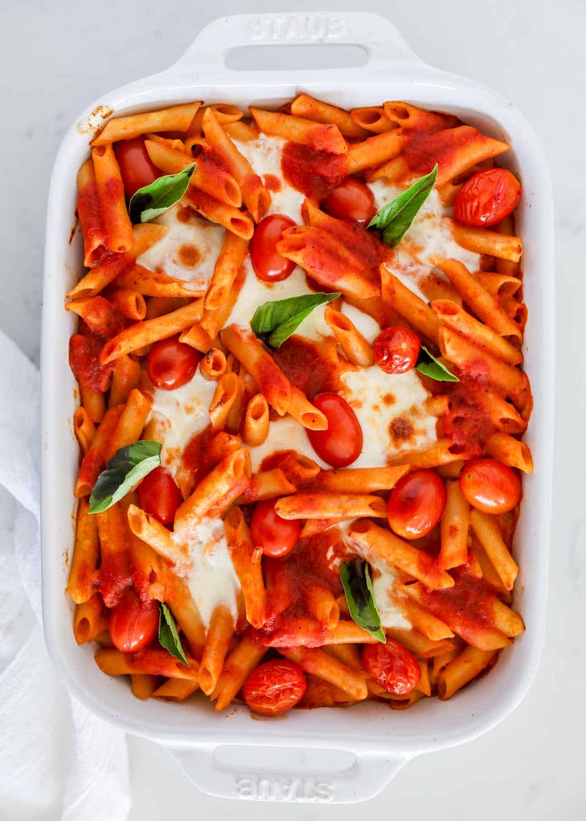 Baked caprese pasta in white dish.