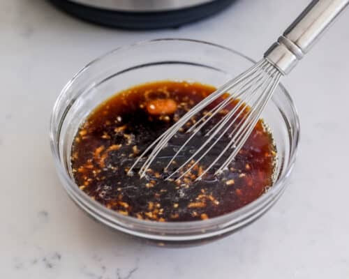 whisking sauce in glass bowl
