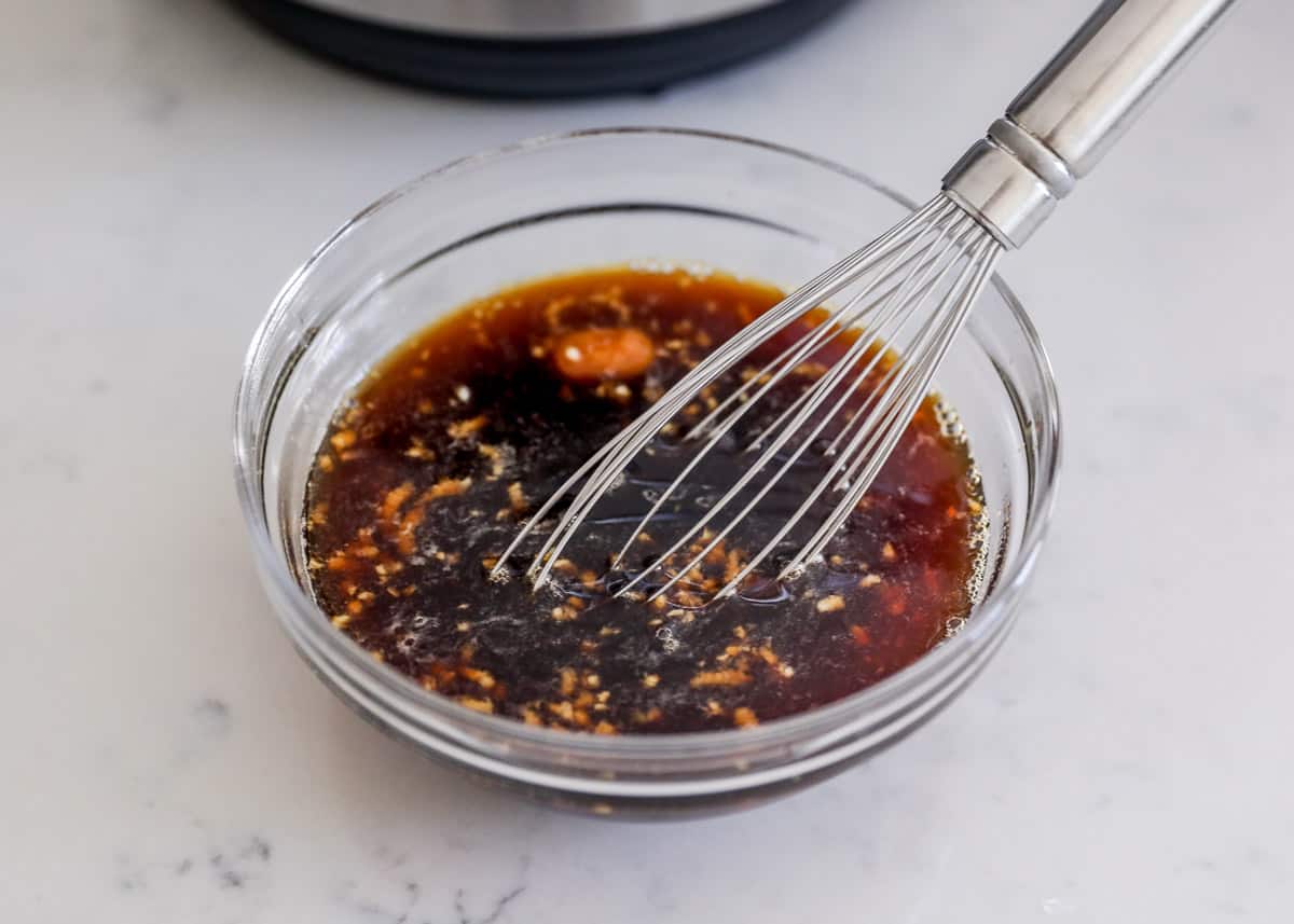 whisking sauce in glass bowl