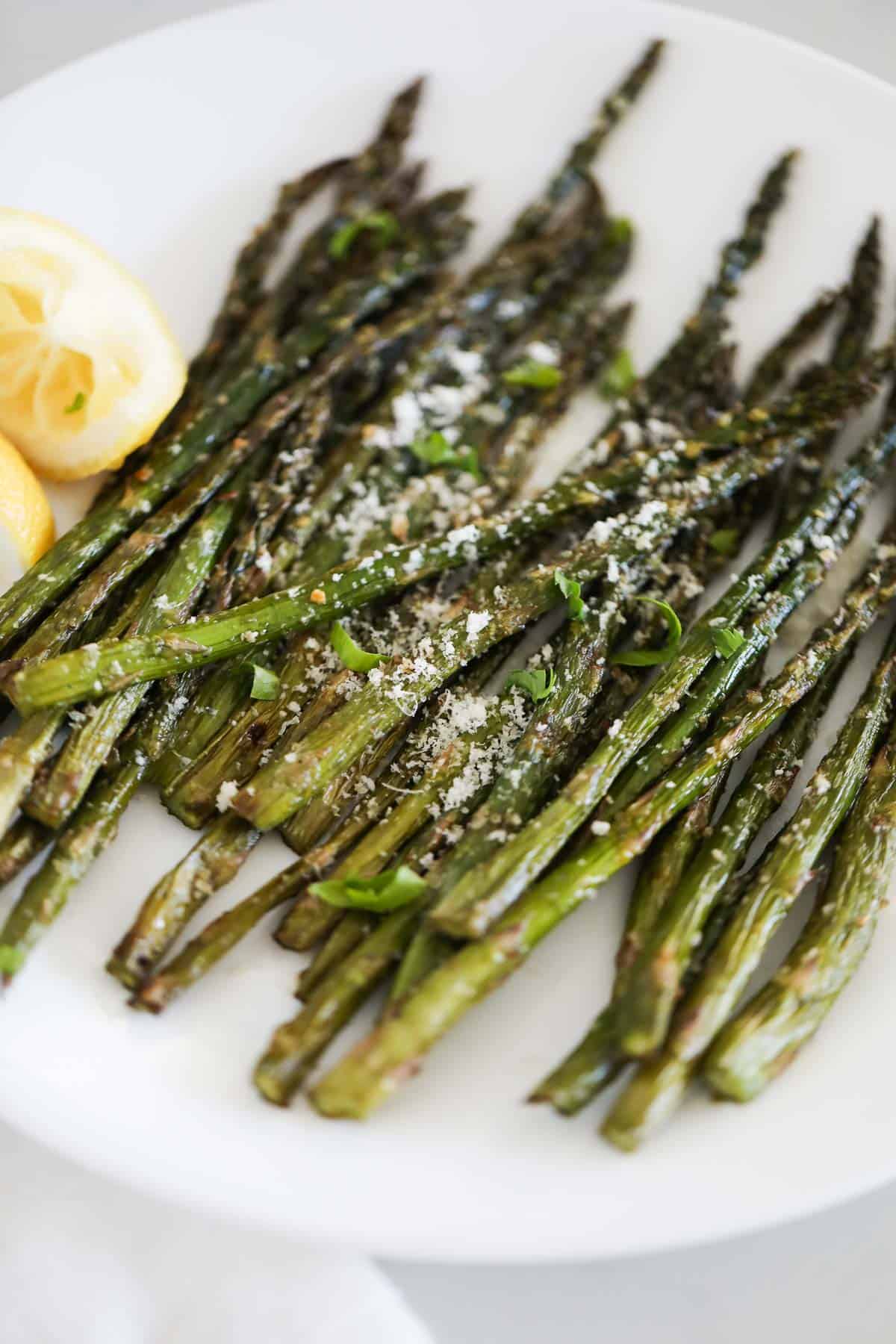 Grilled asparagus on white plate.
