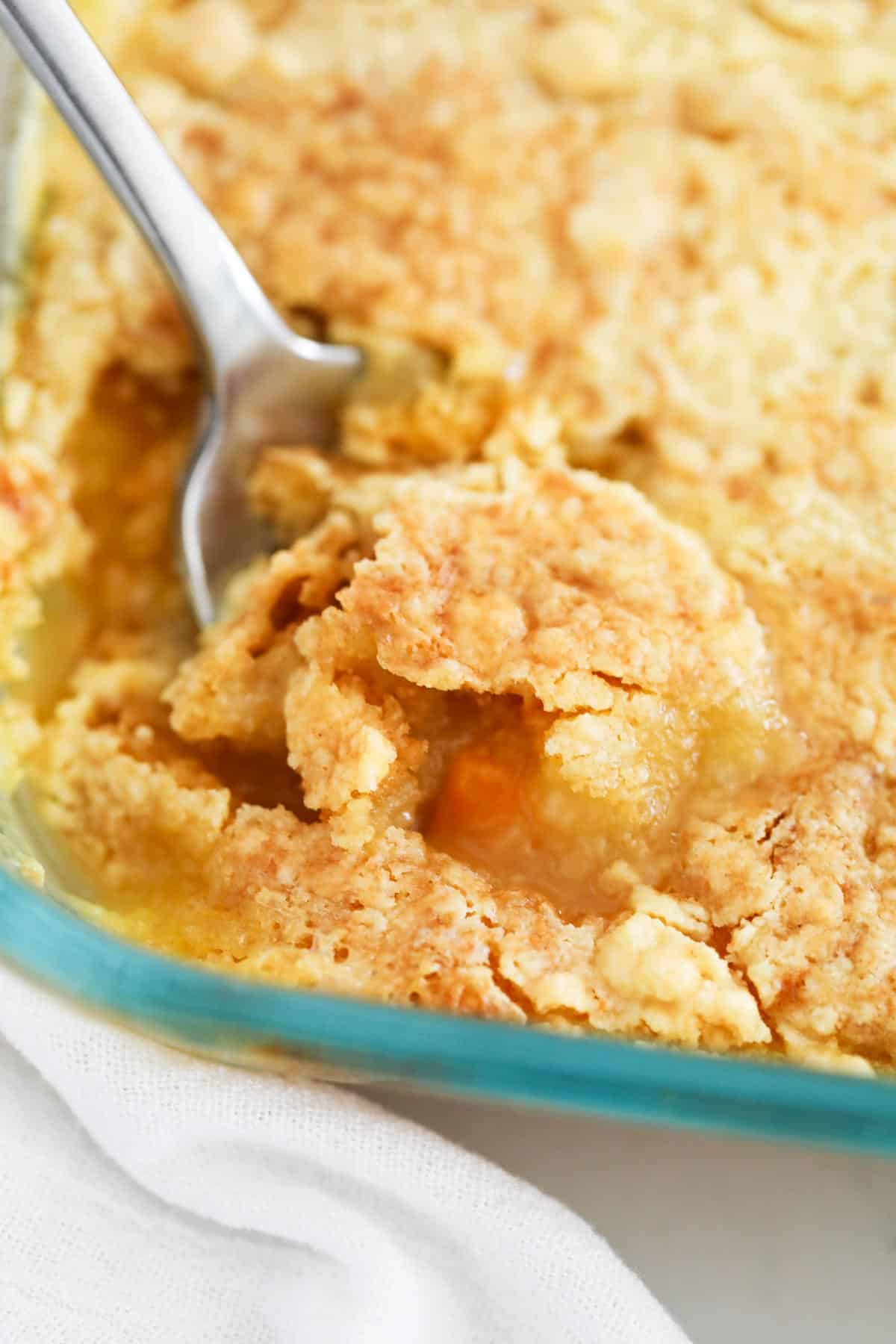 Peach dump cake in clear pan.