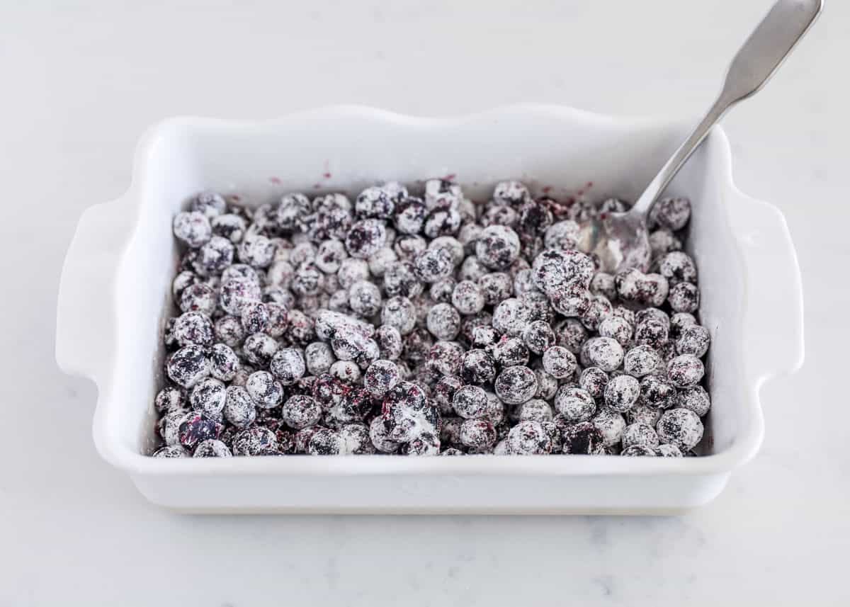 Blueberries in white baking dish tossed with sugar and cornstarch.