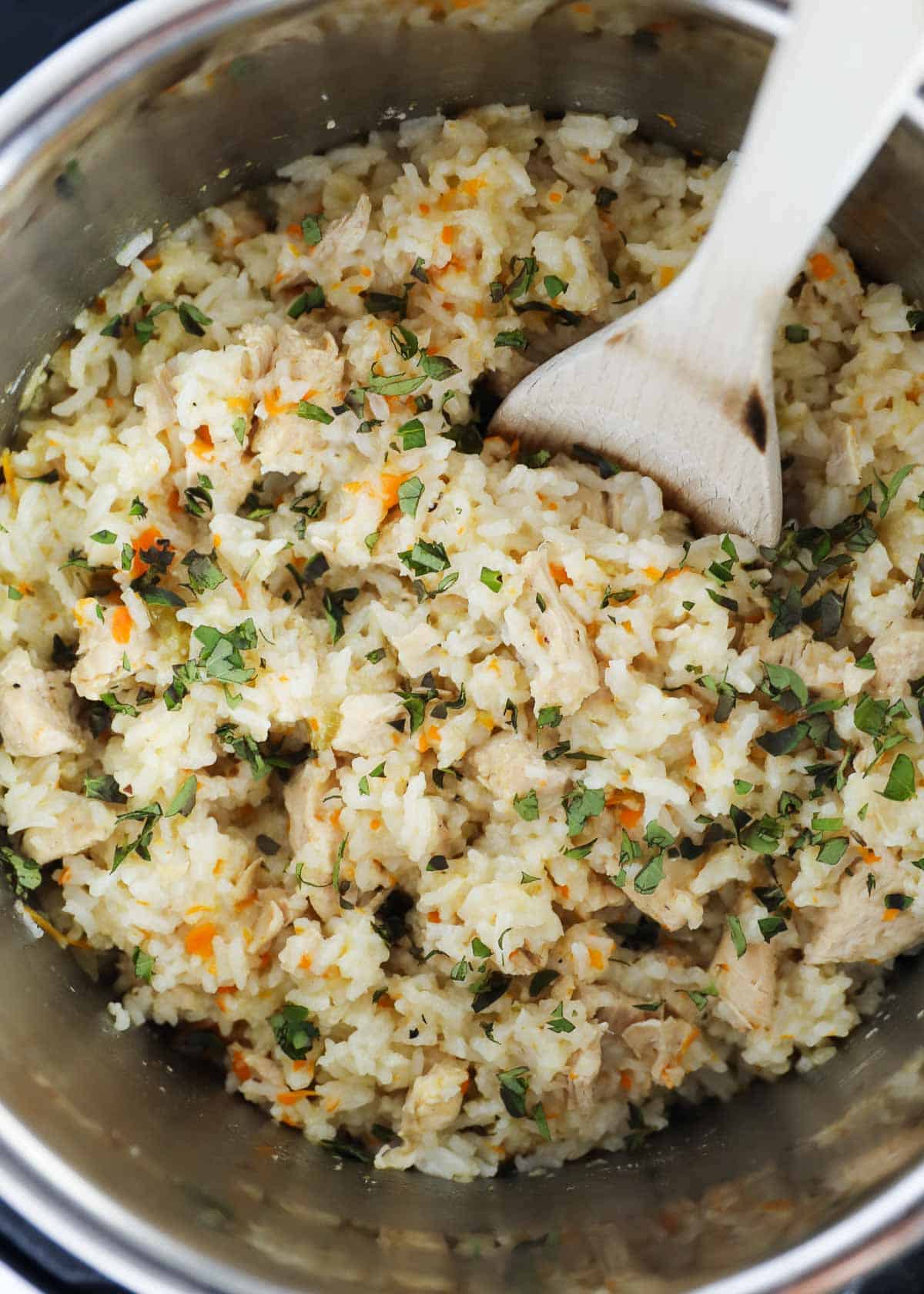 Chicken and rice in instant pot with spoon.