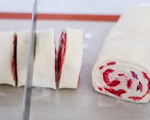 slicing raspberry rolls with knife