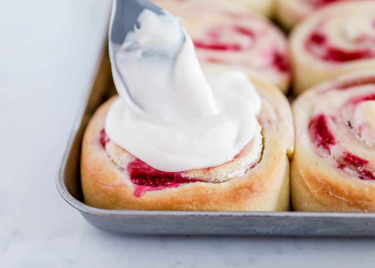 pouring glaze on top of sweet roll