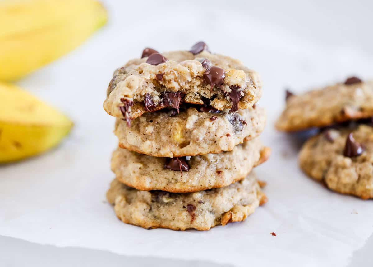 Stacked banana chocolate chip cookies on counter.
