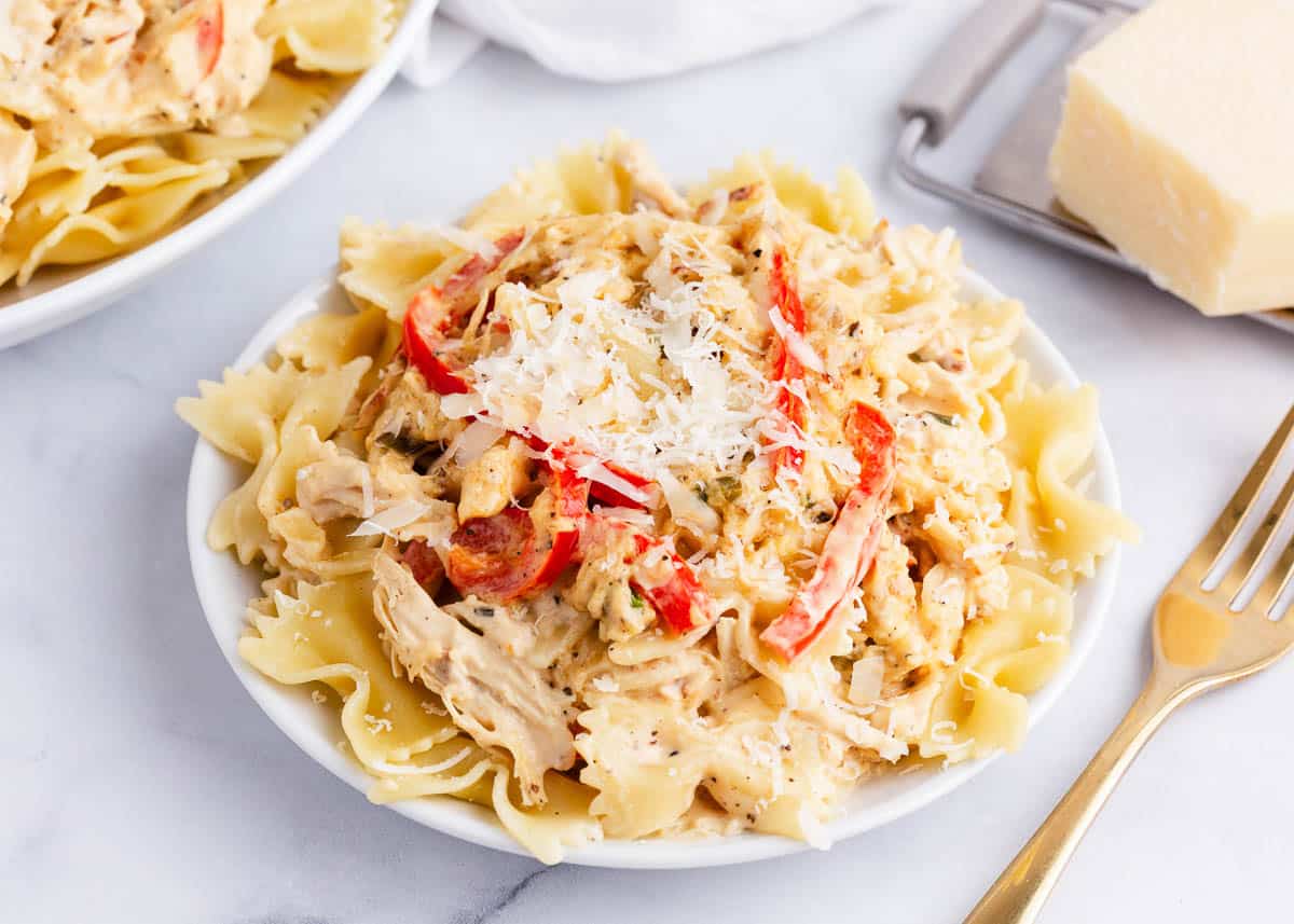 Creamy chicken pasta on white plate.