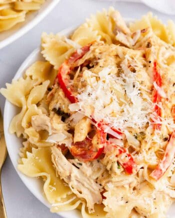 creamy chicken pasta with peppers on white plate