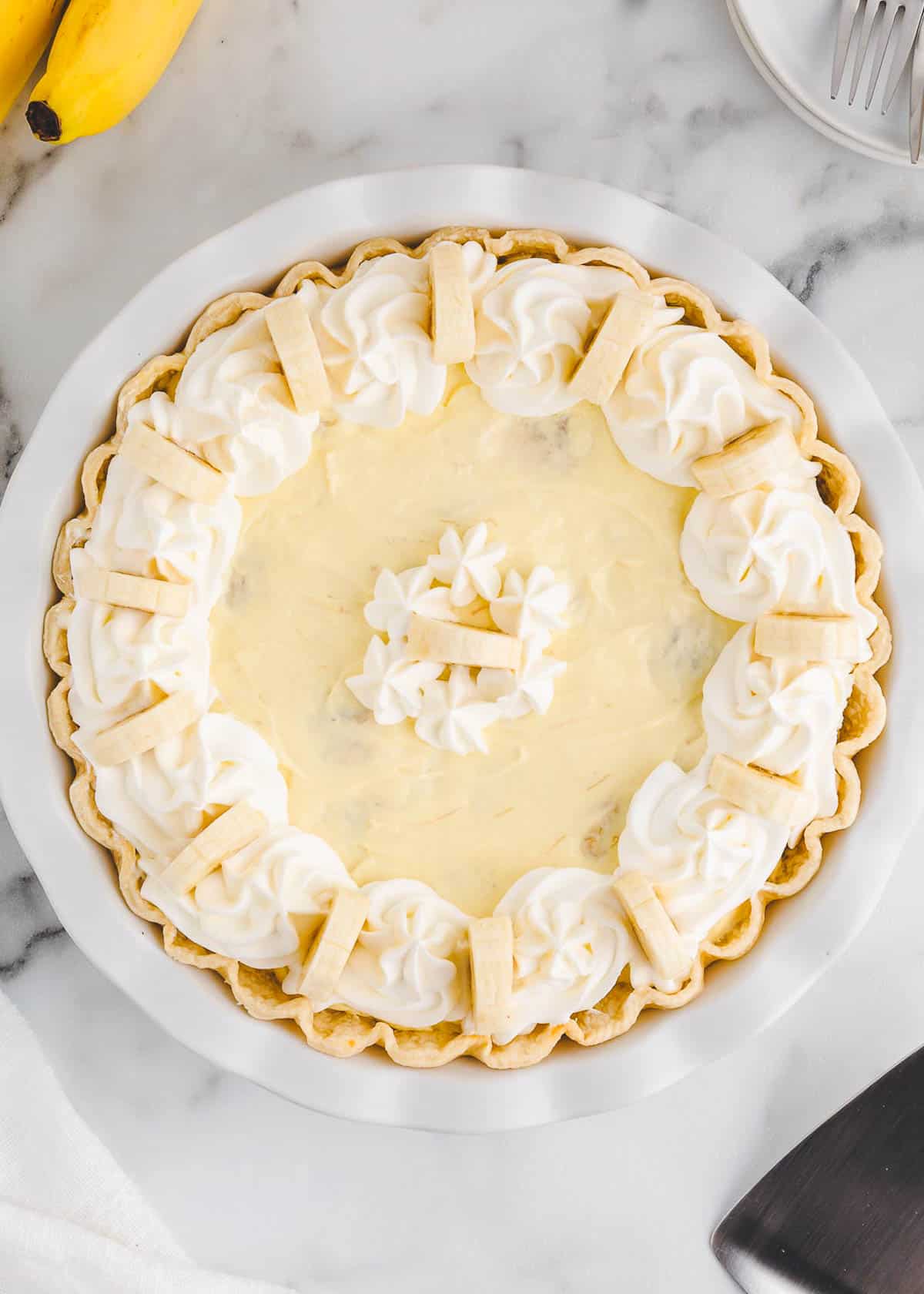 Easy banana cream pie sitting on marble countertop. 