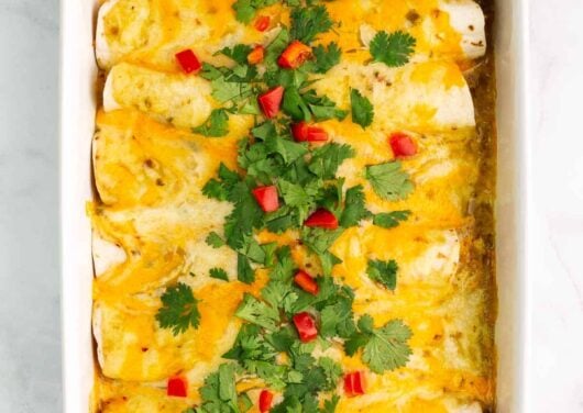 green chile chicken enchiladas in casserole dish