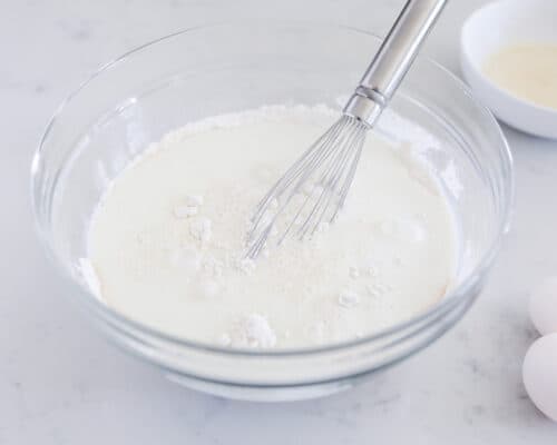 whisking flour and milk in bowl