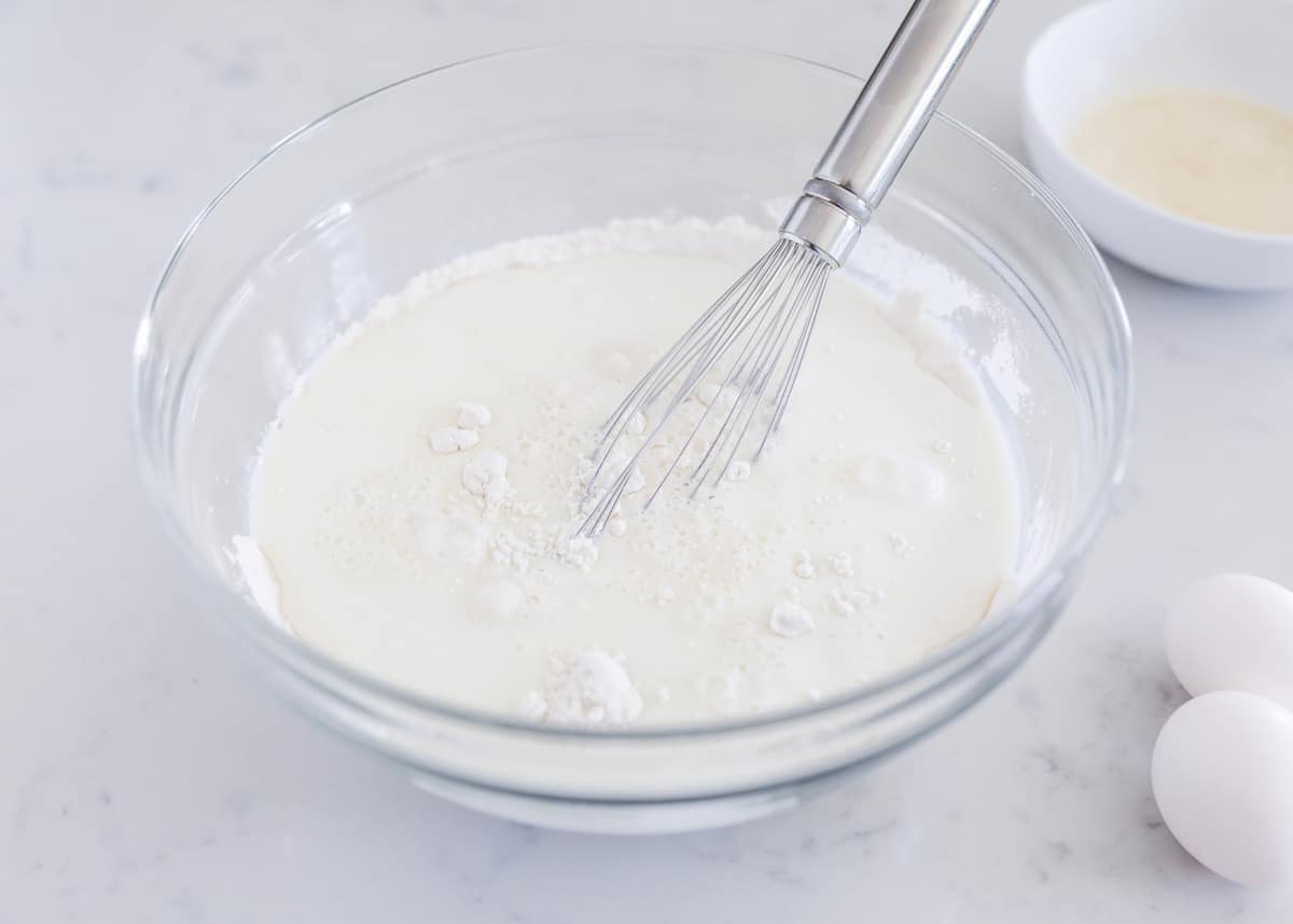 whisking flour and milk in bowl
