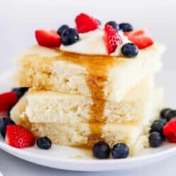 stack of sheet pan pancakes with syrup and berries