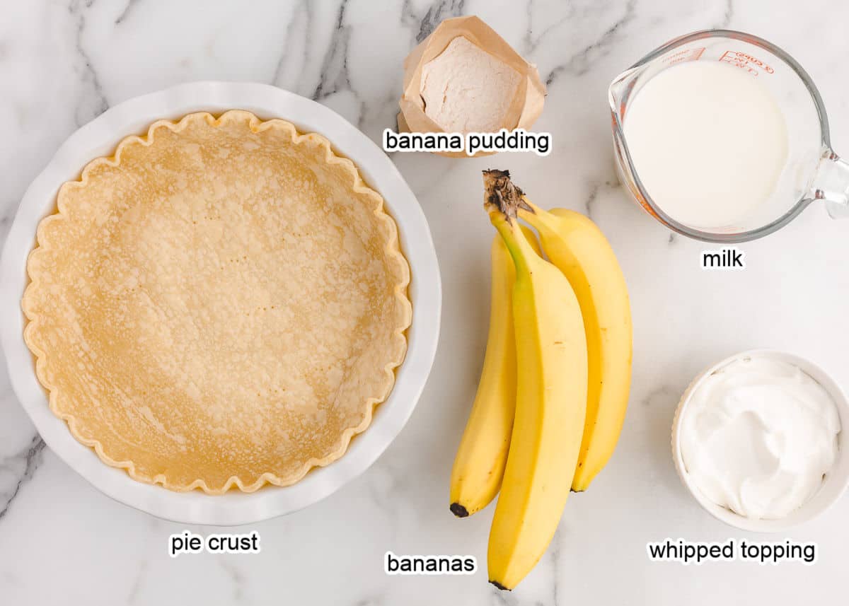 Banana cream pie ingredients on marble countertop.