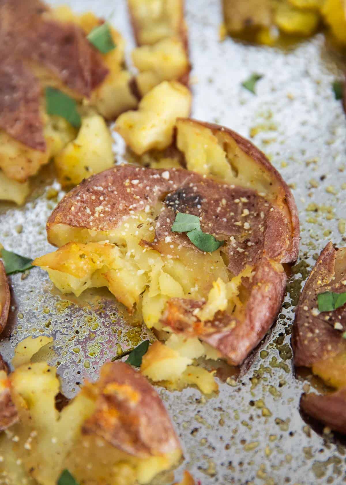 Crispy smashed potatoes on a baking sheet.