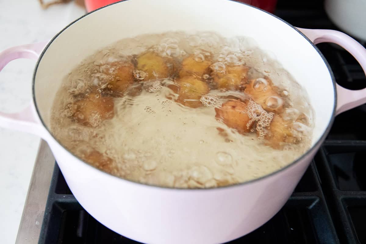 A pot of boiling water with potatoes in it.