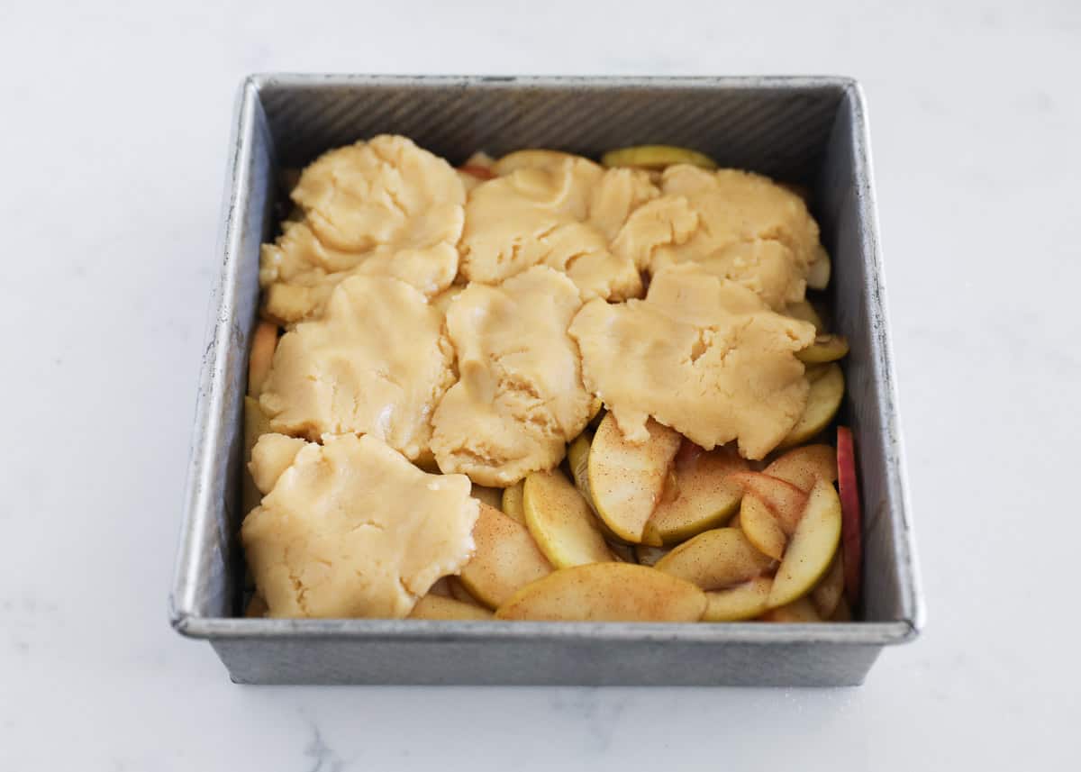 dough on top of apples in pan