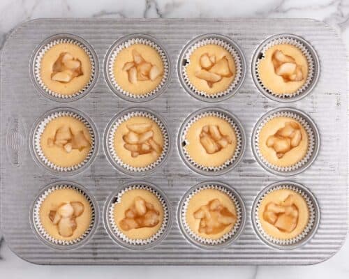 cupcake batter in muffin tin with apple filling