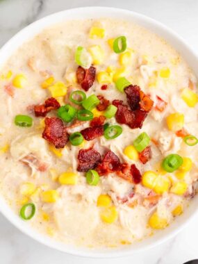 Chicken corn chowder soup garnished with bacon and green onions.