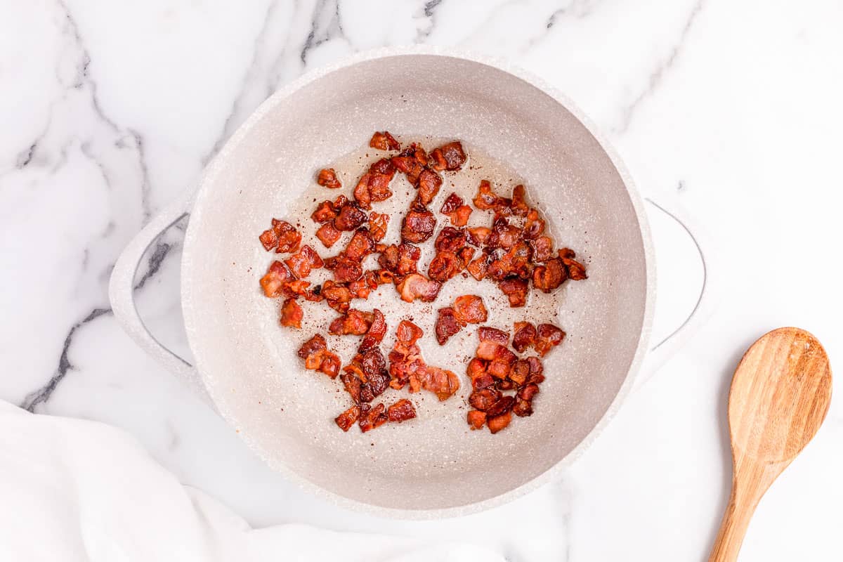 Frying bacon in skillet for chicken corn chowder.