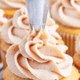 piping cinnamon buttercream on cupcake