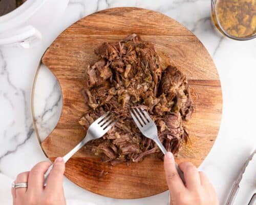 shredding beef on cutting board
