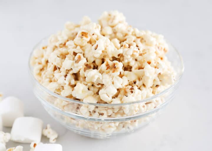 Gooey marshmallow caramel popcorn made with just 4 ingredients in 15 minutes! This mouth-watering treat has all the delicious flavors and textures you could dream of...sweet, salty, crunchy and completely addicting! popcorn in glass bowl