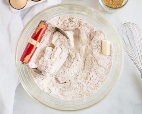 pastry cutter cutting butter and flour in glass bowl