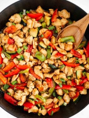 Panda Express Kung Pao chicken copycat with veggies and sauce in a black skillet.