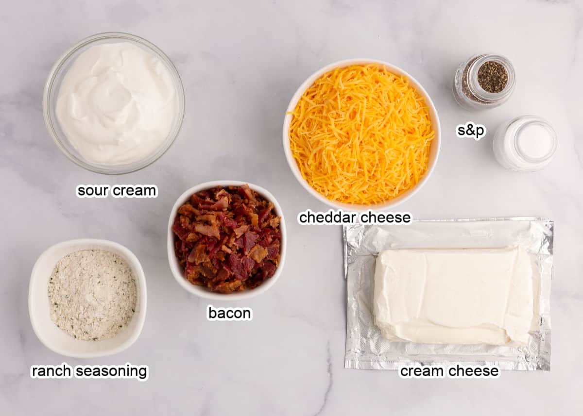 Bacon cheddar ranch dip ingredients on marble counter.