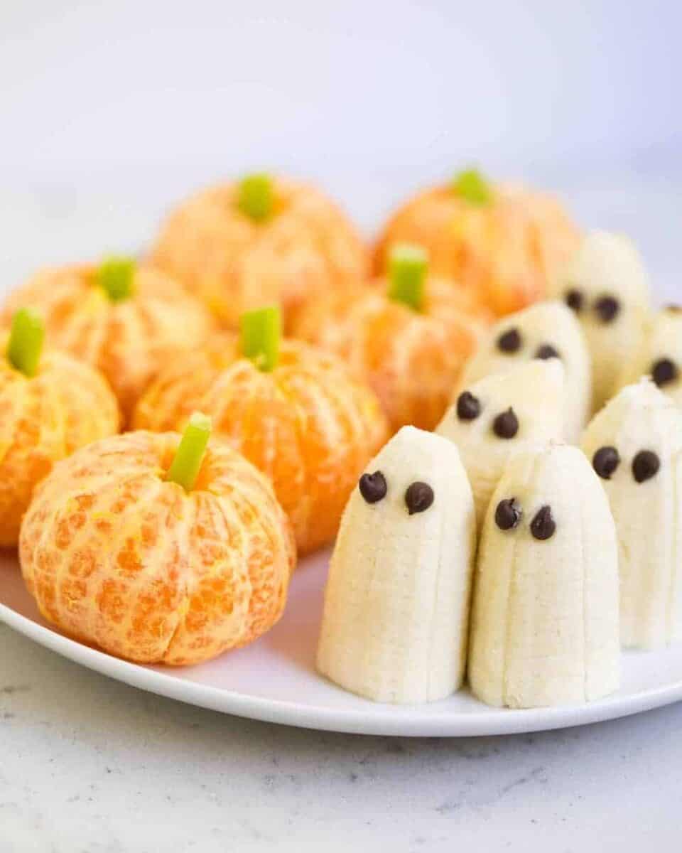 Pumpkin tangerines and ghost bananas are healthy Halloween snacks that kids love.