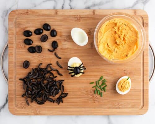 halloween deviled eggs on wooden board